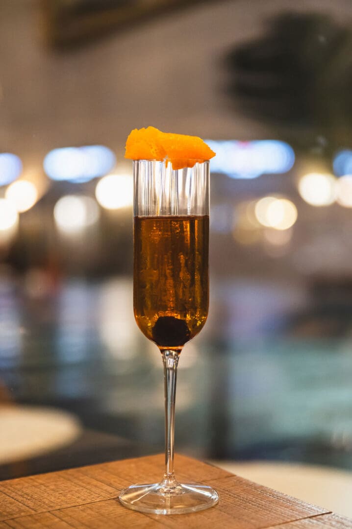 Cocktail servito in flûte con scorza d'arancia
